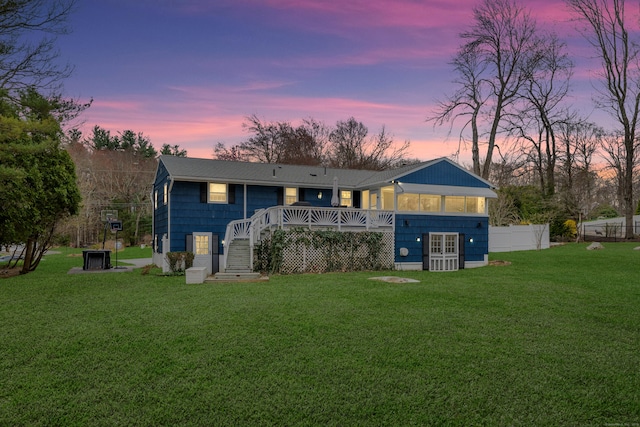 rear view of property with stairs, fence, a yard, and a deck