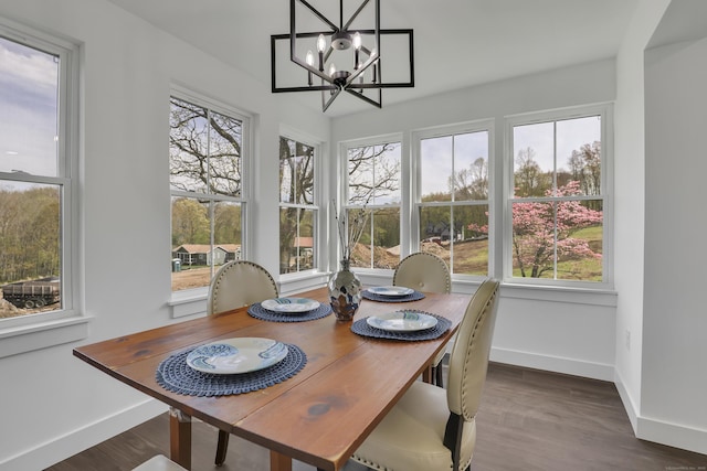 dining room with baseboards, plenty of natural light, a chandelier, and wood finished floors