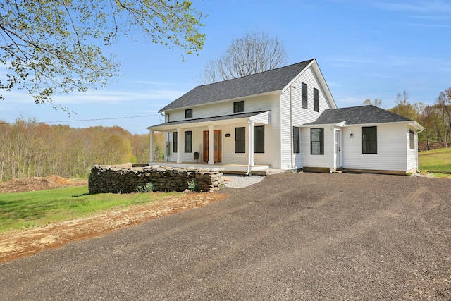 view of front of home with a porch, a shingled roof, and asphalt driveway