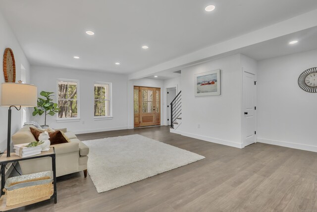 living area featuring stairway, baseboards, wood finished floors, and recessed lighting