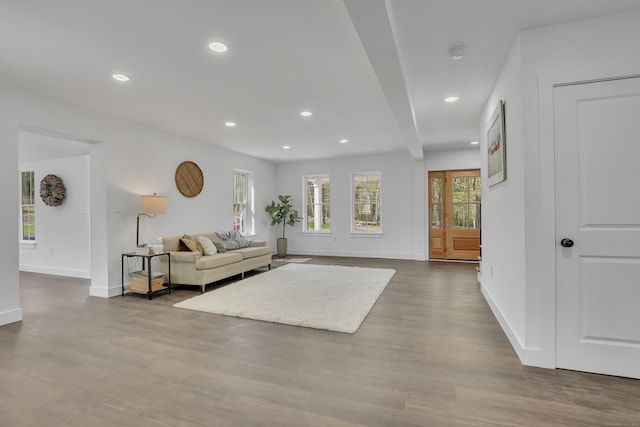 living area with recessed lighting, dark wood-type flooring, and baseboards