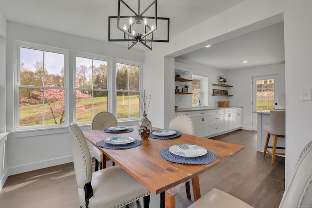 dining space featuring wood finished floors, baseboards, a chandelier, and recessed lighting