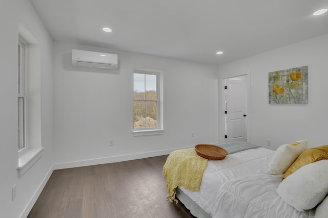 bedroom featuring a wall mounted AC, dark wood-style flooring, recessed lighting, and baseboards