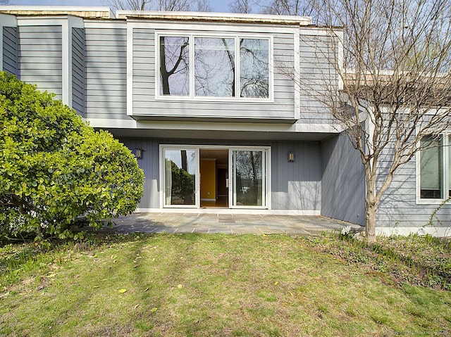 rear view of property with a yard and a patio area