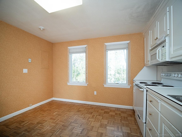 kitchen with white cabinets, baseboards, and white appliances