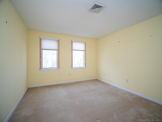 carpeted spare room with baseboards and visible vents