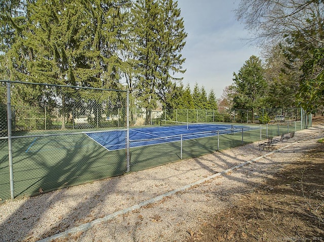 view of tennis court featuring fence