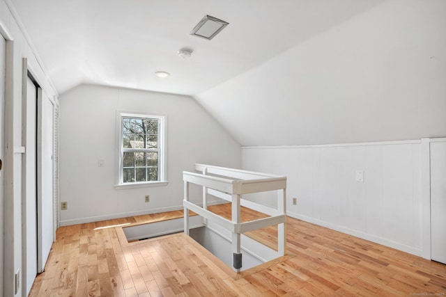 additional living space with vaulted ceiling and wood finished floors