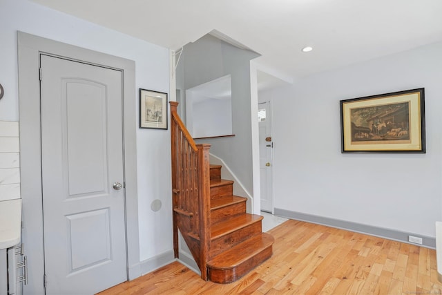staircase featuring wood finished floors, recessed lighting, and baseboards