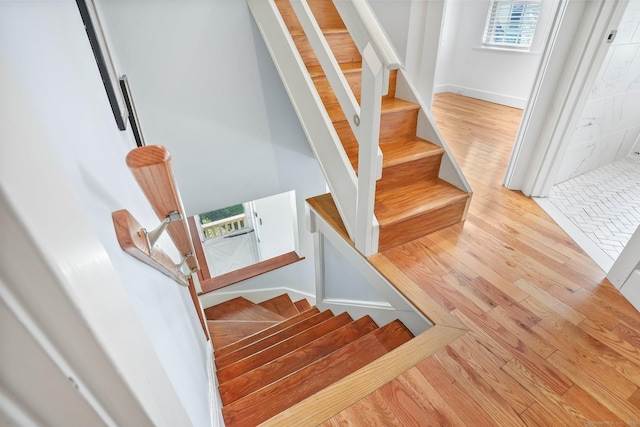 stairway featuring wood finished floors and baseboards