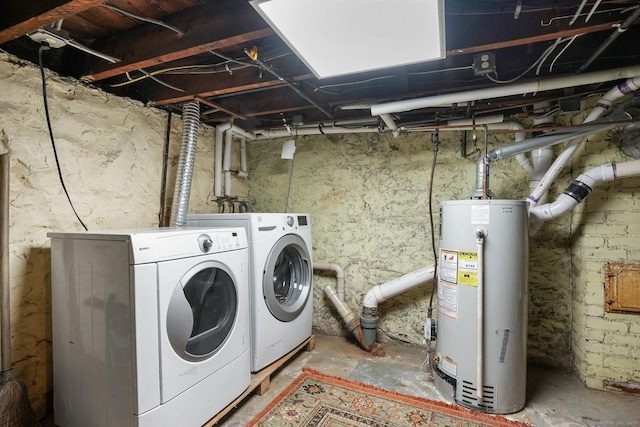 laundry room with gas water heater, washing machine and dryer, and laundry area