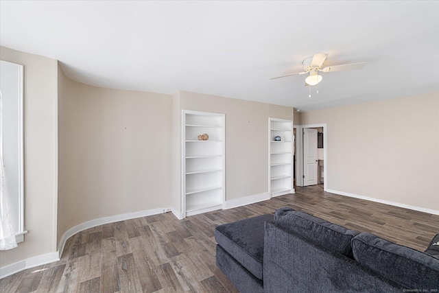 living room with baseboards, ceiling fan, built in features, and wood finished floors