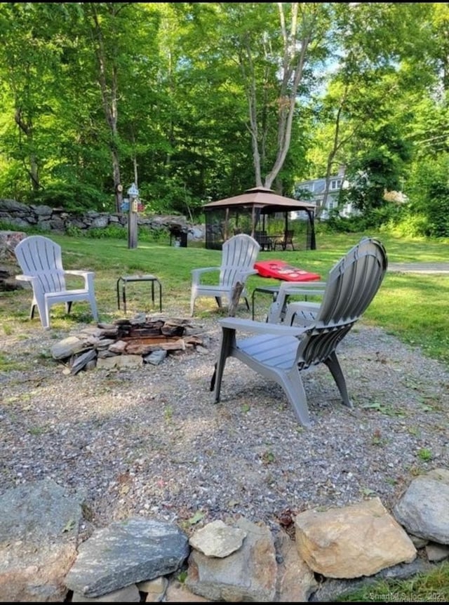 view of yard featuring a gazebo and a fire pit