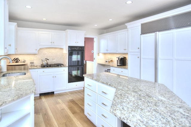 33 Pequot Trl, Westport, CT 06880 - kitchen featuring a sink, paneled fridge, white cabinetry, stainless steel gas cooktop, and recessed lighting