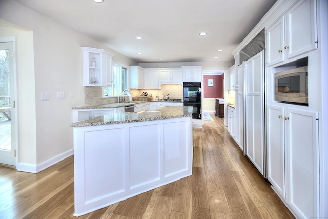 33 Pequot Trl, Westport, CT 06880 - kitchen featuring stainless steel appliances, white cabinets, light wood-type flooring, tasteful backsplash, and recessed lighting