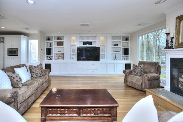 33 Pequot Trl, Westport, CT 06880 - living area with a glass covered fireplace, recessed lighting, light wood finished floors, baseboard heating, and built in shelves
