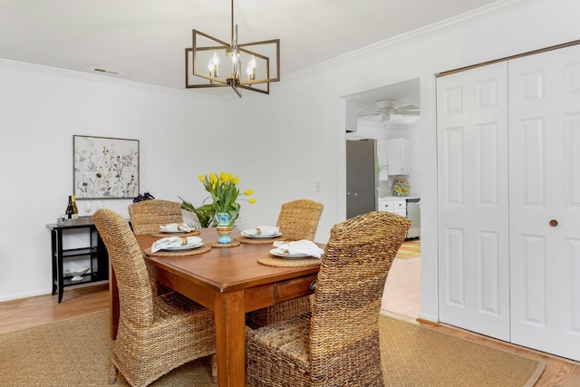 201 Rowayton Woods Dr Unit 201, Norwalk, CT 06854 - dining area with light wood finished floors, an inviting chandelier, and ornamental molding