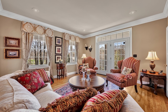living area featuring crown molding, baseboards, plenty of natural light, and wood finished floors