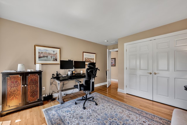 office space featuring baseboards and light wood finished floors