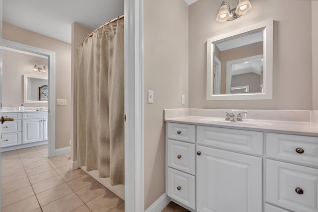 full bath with a shower with curtain, baseboards, tile patterned flooring, and vanity