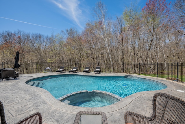view of pool with a patio, a pool with connected hot tub, and fence