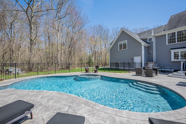 view of pool featuring a patio, a pool with connected hot tub, and fence