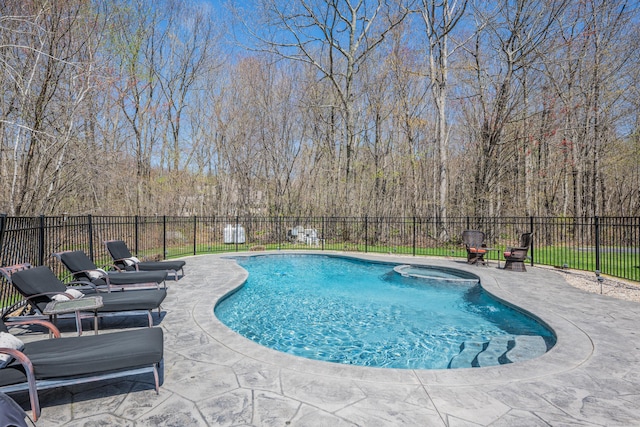 view of swimming pool with a patio, a pool with connected hot tub, and fence