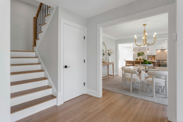 4 Rabbit Ln, Darien, CT 06820 - entrance foyer with crown molding, baseboards, a chandelier, light wood-style flooring, and stairs