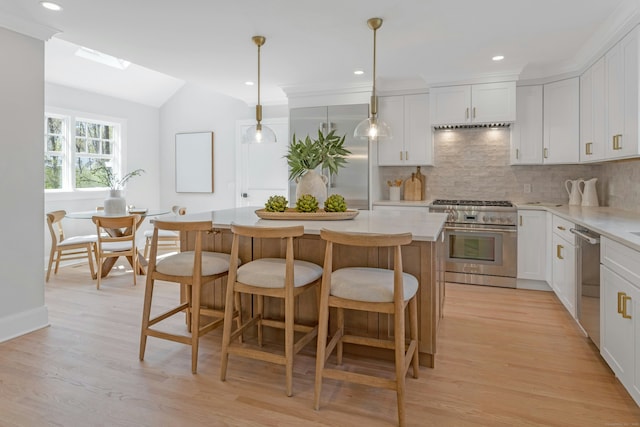 4 Rabbit Ln, Darien, CT 06820 - kitchen featuring stainless steel appliances, light wood-type flooring, a center island, decorative backsplash, and vaulted ceiling with skylight