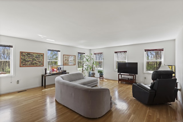 living room featuring visible vents, plenty of natural light, and wood finished floors