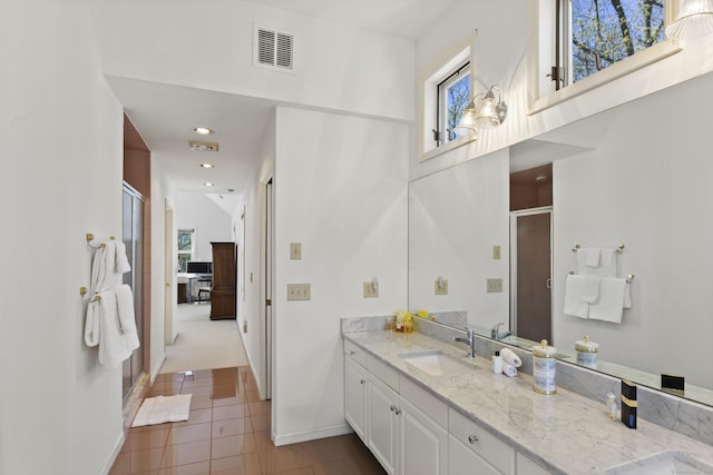bathroom featuring visible vents, tile patterned flooring, a shower stall, vanity, and baseboards
