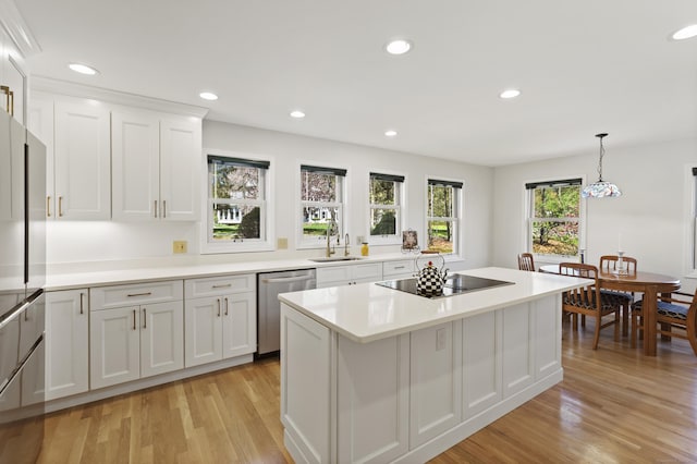 kitchen featuring a sink, light wood finished floors, black electric stovetop, and dishwasher
