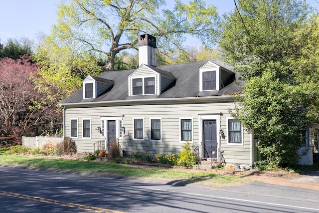 cape cod-style house featuring entry steps and a chimney