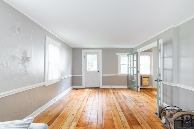 interior space featuring baseboards, crown molding, and hardwood / wood-style flooring