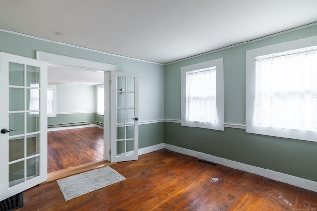 empty room with french doors, crown molding, hardwood / wood-style flooring, baseboards, and a baseboard radiator