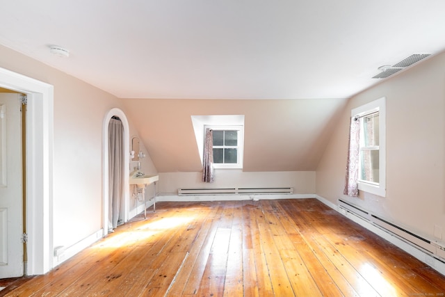 bonus room with light wood-style floors, a baseboard heating unit, and visible vents