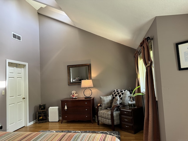 sitting room with high vaulted ceiling, visible vents, and wood finished floors