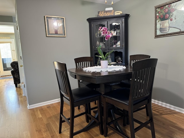 dining space featuring baseboards and wood finished floors