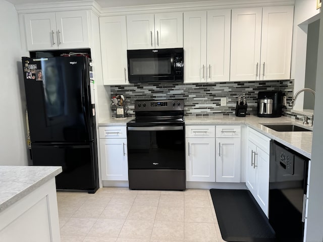 kitchen featuring light tile patterned floors, a sink, white cabinets, black appliances, and decorative backsplash