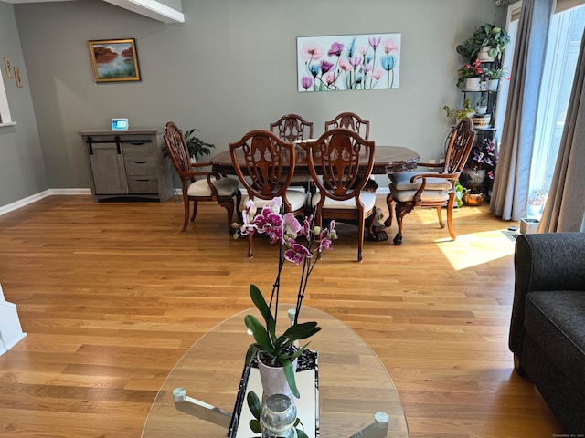 dining area with baseboards, a wealth of natural light, and light wood finished floors