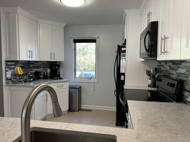 kitchen with light countertops, white cabinetry, decorative backsplash, and black appliances