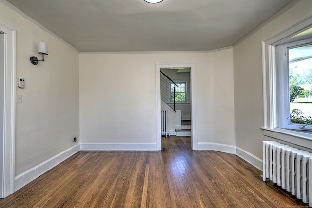 53 Bina Ave, Windsor, CT 06095 - empty room with radiator, dark wood finished floors, crown molding, baseboards, and stairway