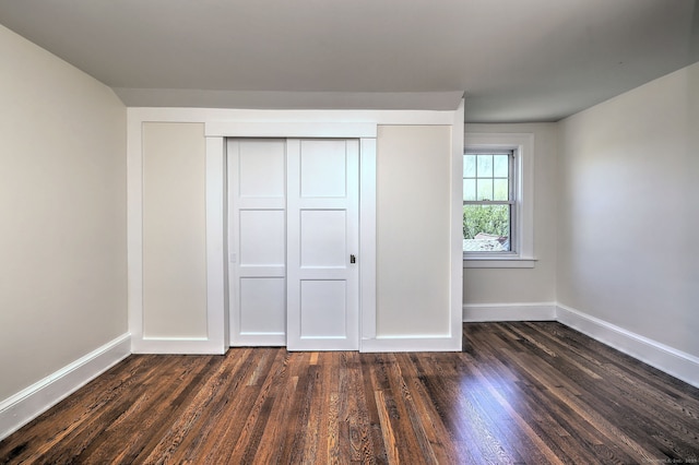 53 Bina Ave, Windsor, CT 06095 - unfurnished bedroom with baseboards, dark wood-style flooring, and a closet