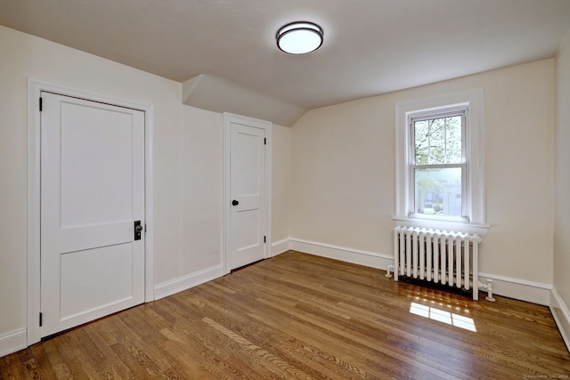 53 Bina Ave, Windsor, CT 06095 - unfurnished bedroom with radiator, wood finished floors, baseboards, and vaulted ceiling