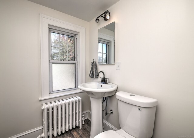 53 Bina Ave, Windsor, CT 06095 - bathroom featuring radiator heating unit, toilet, wood finished floors, a sink, and baseboards
