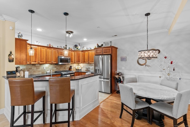95 S Ridge Ln Unit G103, Berlin, CT 06037 - kitchen with a peninsula, appliances with stainless steel finishes, pendant lighting, brown cabinets, and ornamental molding