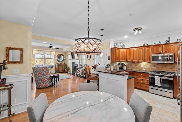 95 S Ridge Ln Unit G103, Berlin, CT 06037 - kitchen featuring brown cabinetry, a fireplace, tasteful backsplash, appliances with stainless steel finishes, and open floor plan