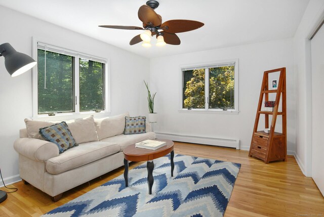 8 Oak Ln, Weston, CT 06883 - living room featuring a baseboard radiator, baseboards, a ceiling fan, and light wood-style floors