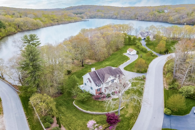 aerial view with a water view and a wooded view