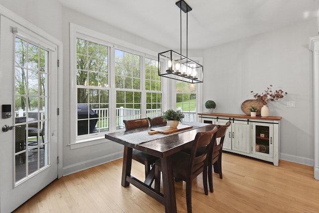 dining area featuring baseboards, a healthy amount of sunlight, and light wood-type flooring